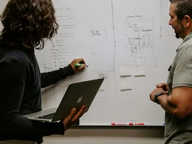Zwei Personen vor einem Whiteboard
